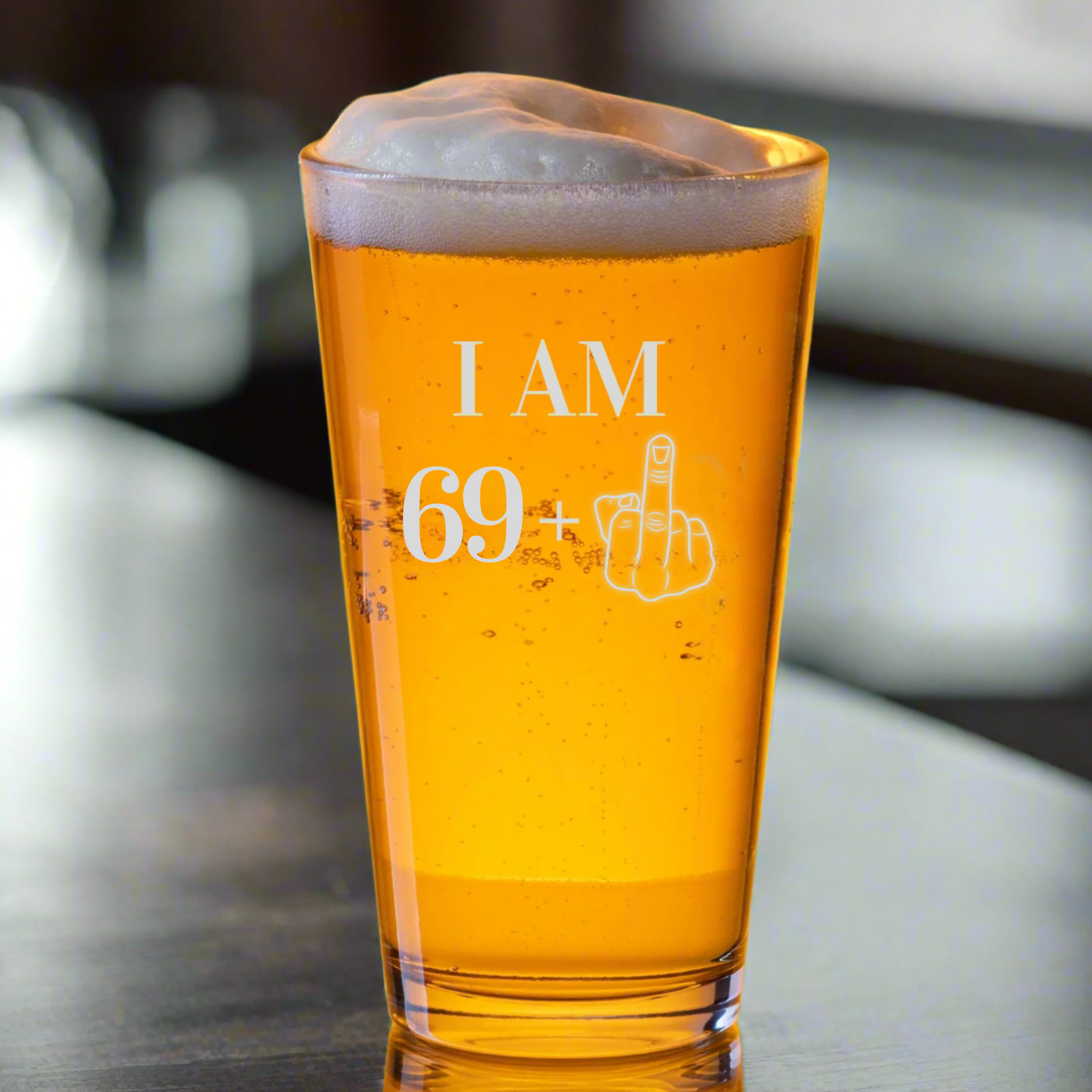 70th birthday pint glass with playful "I AM 69+" message